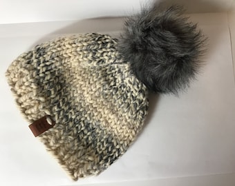 Hand knit adult winter hat acrylic wool blend yarn in off white black an grey with grey faux fur Pom pom, bulky, warm
