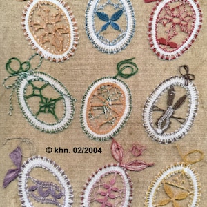 May include: Nine handmade crocheted oval ornaments in various colors, including red, blue, green, orange, and purple. Each ornament features a different lace design. The ornaments are displayed on a beige fabric background. © khn. 02/2004