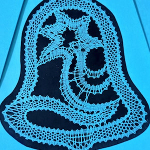 Könnte beinhalten: Ein weißes Spitzenmuster in Form einer Glocke, vor blauem Hintergrund.