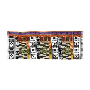 May include: A rectangular textile with a vibrant African-inspired pattern. The design features repeating geometric shapes in black and white, accented with orange, green, and purple. The edges are finished with a fringed trim.