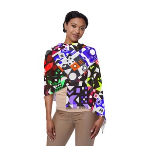 May include: A colorful scarf with a geometric pattern. The scarf features a mix of shapes and colors, including red, blue, black, white, and green. The scarf is fringed at the ends.