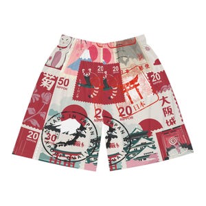 May include: White and red patterned shorts featuring Japanese imagery. The design includes stamps with red pandas, Mount Fuji, and Japanese text. The shorts have an elastic waistband and a relaxed fit, perfect for casual wear.