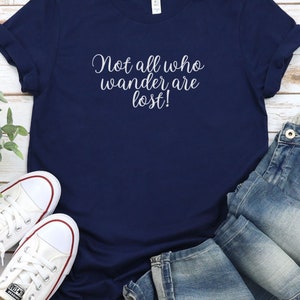 May include: A navy blue t-shirt with the text "Not all who wander are lost!" in white lettering.