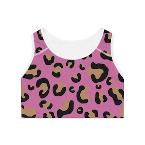 Op de afbeelding: Roze sportbeha met een luipaardprint. De print heeft bruine en zwarte vlekken op een roze achtergrond.