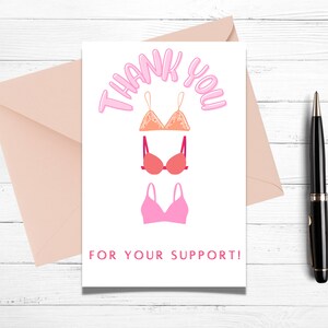 May include: A white card with the text "Thank You" in pink letters and three pink and orange bras. The text "For Your Support!" is printed below the bras.