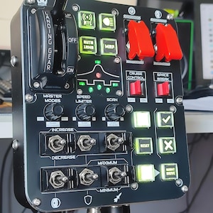 Pode incluir: Painel de controle preto com vários interruptores, botões e alavancas. Inclui uma alavanca de trem de aterrissagem, interruptores basculantes marcados "Increase" e "Decrease", e botões iluminados para "Cruise Control" e "Space Break".
