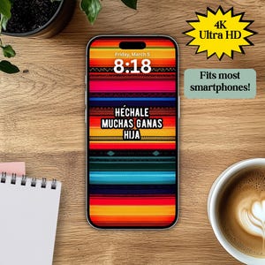 Könnte beinhalten: Eine farbenfrohe Handy-Tapete mit mexikanisch inspiriertem Design, das ein gestreiftes Muster in Rot-, Orange-, Gelb-, Blau- und Grüntönen zeigt. Der Text "HECHALE MUCHAS GANAS HIJA" ist in Weiß auf schwarzem Hintergrund dargestellt. Die Tapete enthält auch eine digitale Uhr, die die Zeit "8:18" und das Datum "Friday, March 5" anzeigt.