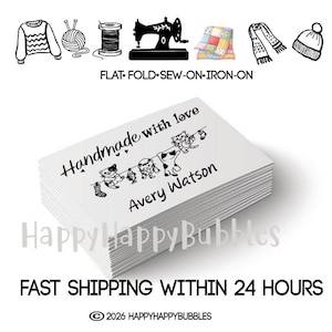 May include: A stack of white rectangular organic cotton labels featuring the black printed text Handmade with love, the name Avery Watson, and a graphic of three cats hanging laundry on a line. The top of the image displays icons of clothing and sewing tools.
