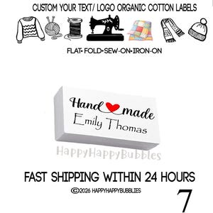 Op de afbeelding: Een rechthoekig wit stoffen label met de zwarte tekst Hand made, een rood hartsymbool en de naam Emily Thomas eronder gedrukt. Boven het label staan zwarte iconen van een trui, garen, draad, naaimachine, quilt, sjaal en muts.
