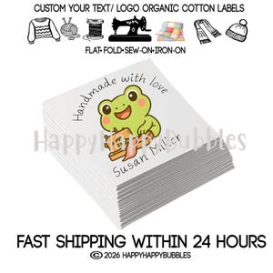 May include: A stack of square white organic cotton labels featuring a cartoon green frog sewing with a small machine. The text reads Handmade with love and Susan Miller. Above the stack are icons of clothing, yarn, thread, a sewing machine, and hats.