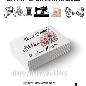 May include: A stack of rectangular white organic cotton labels featuring the printed text Hand made With LOVE by Anne Hansen, decorated with pink flowers and hearts. Above, icons of a sweater, yarn, spool, sewing machine, quilt, scarf, and hat.