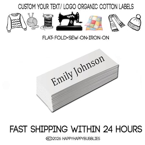 以下が含まれることがあります： Emily Johnsonと黒字で印刷された白い長方形のオーガニックコットンラベルの束。上部にはセーター、毛糸、糸巻き、ミシン、キルト、スカーフ、帽子のアイコンがあり、CUSTOM YOUR TEXT/LOGO ORGANIC COTTON LABELSおよびFLAT-FOLD-SEW-ON-IRON-ONというテキストが記載されています。