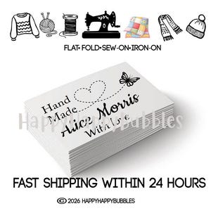 May include: A stack of white rectangular organic cotton labels featuring the black printed text Hand Made, Alice Morris, and With Love, accompanied by a dashed heart and butterfly graphic. The top includes icons of clothing and sewing tools.