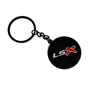 May include: Black metal keychain with a round black charm featuring the white text "LSX" with a red diagonal slash through the X.