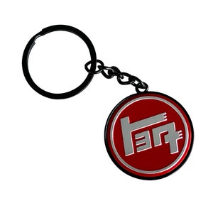 May include: A black metal keychain with a red circular charm featuring a silver Toyota logo.