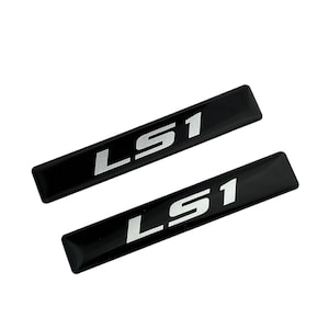 May include: Two black rectangular stickers with the text "LS1" in silver lettering.