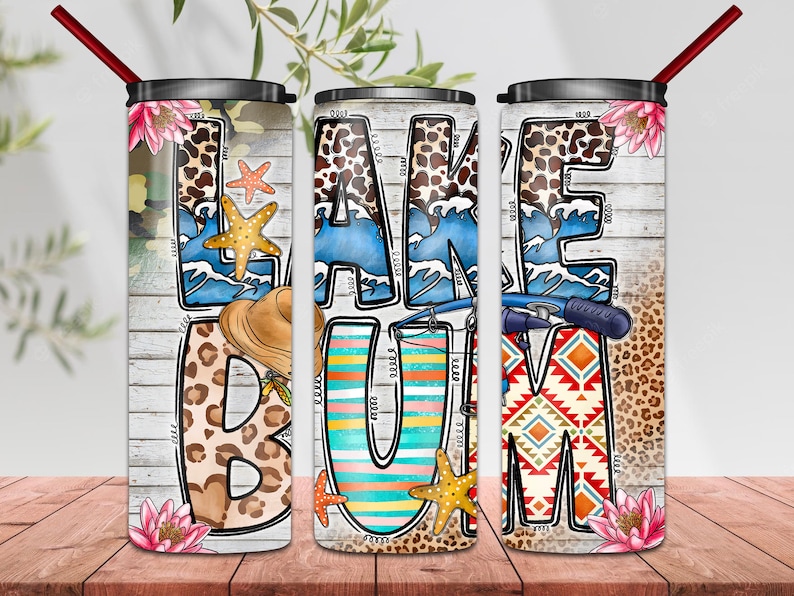 May include: Three stainless steel tumblers with a white background and colorful designs. The tumblers feature the words "LAKE BUM" with various patterns and images, including waves, starfish, and fishing poles.