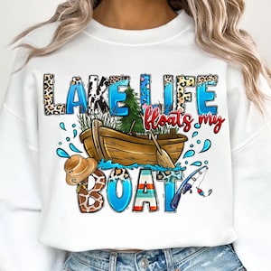 May include: White sweatshirt with a colorful graphic design that says "Lake Life floats my boat". The graphic includes a boat, a fishing rod, a hat, and a giraffe print.