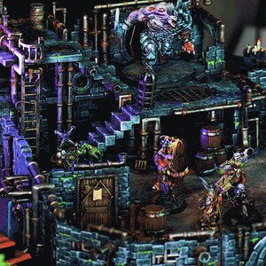 May include: A detailed miniature dungeon set with a green, blue and brown colour scheme. The set features a multi-level structure with stairs, a small door and a large, menacing figure at the top. There are several smaller figures throughout the set, including a figure holding a barrel.