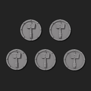 May include: Six gray metal round tokens with a raised image of a hammer and a shield. The tokens are approximately 2 inches in diameter.
