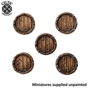 May include: Five circular miniature bases featuring a brown wood plank texture with a metallic rim and rivet details. The top left corner displays the text Celtic Miniatures, and the bottom right corner includes the text Miniatures supplied unpainted.