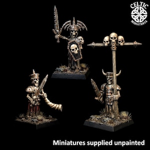 May include: Three skeleton warrior miniatures on square bases. One holds a sword and shield with a skull emblem, one blows a horn while holding a sword, and one holds a tall staff topped with three skulls. The text reads Celtic Miniatures.