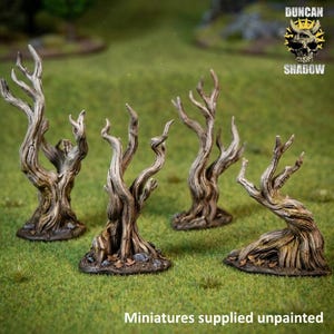 Peut inclure: Quatre arbres miniatures morts avec des textures d'écorce noueuses, brun clair et gris. Chaque arbre présente des branches torsadées et une base large avec de petites roches et feuilles sculptées. Le texte DUNCAN SHADOW et Miniatures supplied unpainted est visible.