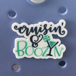 May include: White sticker with black and green text that reads "cruisin' & boozin'". A green lime and a black cocktail glass are also on the sticker.