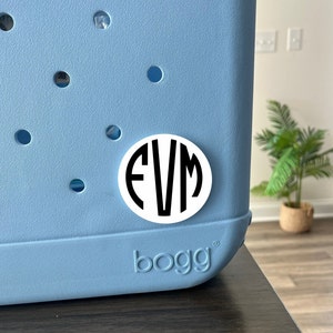 Könnte beinhalten: Ein weißer runder Aufkleber mit schwarzen Buchstaben "EVM" auf einer hellblauen Kühlbox mit dem Wort "bogg" unten.