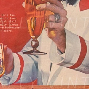 Puede incluir: Un anuncio vintage de cerveza Budweiser con un hombre sosteniendo un vaso de cerveza. El texto dice "KNOW HIM? He's the easiest man in town to meet. Just visit your friendly tavern and ask for Budweiser...King of Beers."
