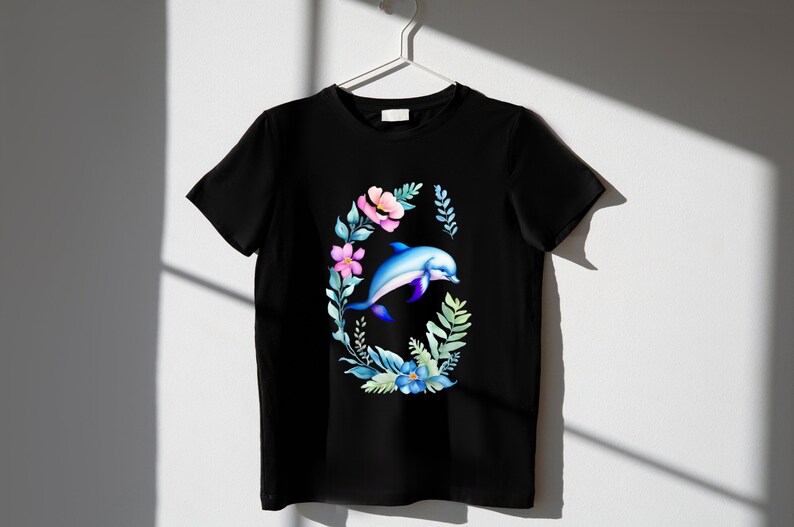 May include: Black t-shirt with a watercolor design of a dolphin jumping through a wreath of flowers.