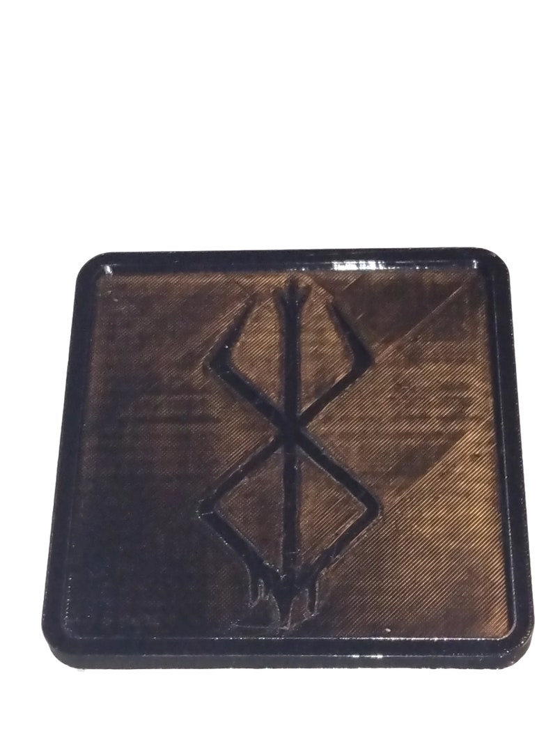 Pu&ograve; includere: Un sottobicchiere quadrato nero con un design in rilievo nero stampato in 3D del simbolo "S" della serie anime Berserk.