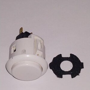 Puede incluir: Bot&oacute;n de arcade blanco con un interruptor negro y dorado y un anillo de montaje de pl&aacute;stico negro.