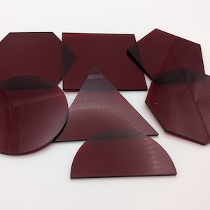 以下が含まれることがあります： アクリル製の8つの幾何学的な形をした、ワインレッド色のセット。円、三角形、正方形、六角形、八角形が3つ含まれています。