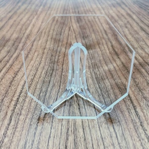May include: A clear acrylic octagon-shaped display stand with a three-pronged base.