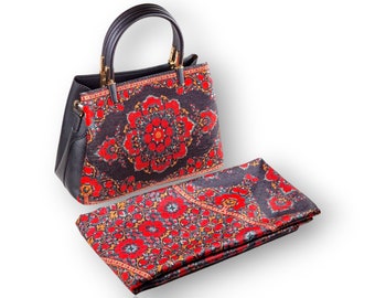 Black synthetic leather bag with handles and a matching square scarf, both with a beautiful floral design of a Persian carpet in reddish tones.