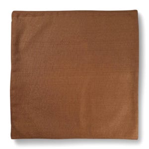 May include: A square, brown pillow cover with a textured surface. The pillow cover is a solid color and appears to be made of a soft fabric. The pillow cover is likely for home decor.