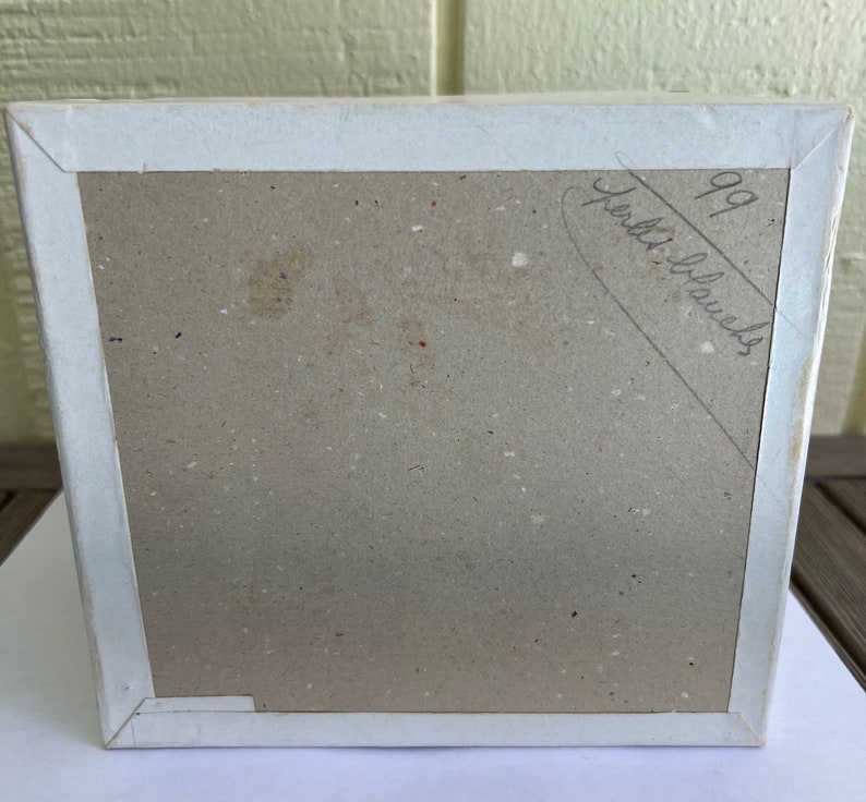 May include: A white cardboard box with a brown interior. The box has a handwritten inscription that reads "99 puzzle blocks".
