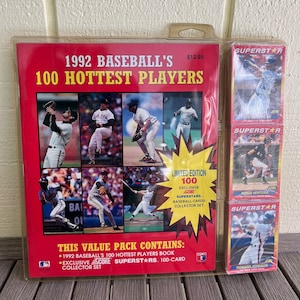 May include: A red and white book titled "1992 Baseball's 100 Hottest Players" with a picture of baseball players on the cover. The book is part of a value pack that includes a 100-card collector set of baseball cards.