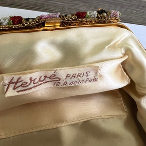 May include: A vintage beaded evening bag with a gold metal frame and a satin lining. The bag has a label that reads "Herm&eacute;s Paris 12, Rue de la Paix".