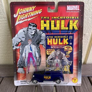 Peut inclure: Une voiture jouet Johnny Lightning avec le personnage de The Incredible Hulk. L'emballage rouge présente des illustrations de la bande dessinée Hulk et une camionnette bleue avec "Hulk" imprimé. L'emballage comprend un avertissement pour les petites pièces.
