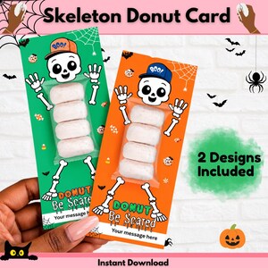 May include: Two rectangular cards featuring a skeleton illustration wearing a baseball cap with the text BOO! and DONUT Be Scared. Each card has a clear plastic sleeve containing four small white powdered donuts. The cards are green and orange.
