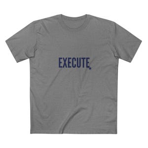 May include: A grey t-shirt featuring the word "EXECUTE" in navy blue, with a small star. The top has a crew neck and short sleeves.