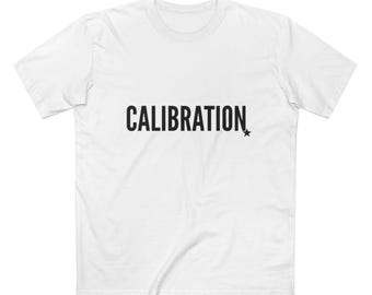 May include: White t-shirt with the word "CALIBRATION" printed in black, accompanied by a small black star. The shirt has a crew neck and short sleeves. The fabric appears to be a soft, comfortable material.