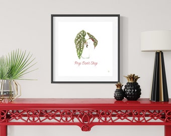 Puede incluir: Una impresión enmarcada de una ilustración de acuarela de una planta de interior con lunares blancos en un frasco de vidrio. El texto "Pray Don't Shop" está escrito en rojo debajo de la planta.