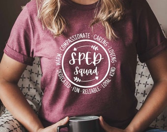 Może przedstawiać: Bordowy t-shirt z białym kołem z napisem "SPED Squad" otoczonym pozytywnymi słowami, takimi jak "ciepły", "współczujący", "troskliwy", "kochający", "życzliwy", "oddany", "zabawny", "niezawodny" i "lojalny".