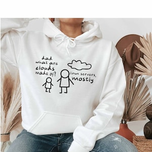 Może przedstawiać: Biała bluza z kapturem z czarnym nadrukiem chmury z tekstem "serwery linux, głównie" i postacią z patyków. Na bluzie znajduje się również tekst "Tato, z czego są chmury?"