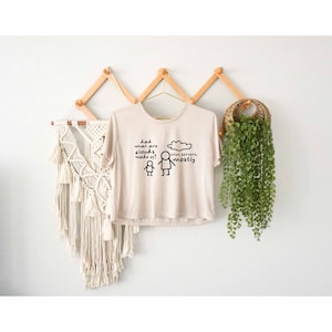 May include: A beige t-shirt with a graphic of a stick figure asking "Dad, what are clouds made of?" and another stick figure pointing to a cloud with the text "Linux servers, mostly."