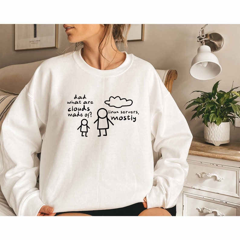 K&ouml;nnte beinhalten: Wei&szlig;er Pullover mit einem schwarzen Aufdruck, der "Papa, woraus bestehen Wolken?" und eine Strichm&auml;nnchenfigur, die auf eine Wolke mit dem Text "Linux-Server, meistens." zeigt.
