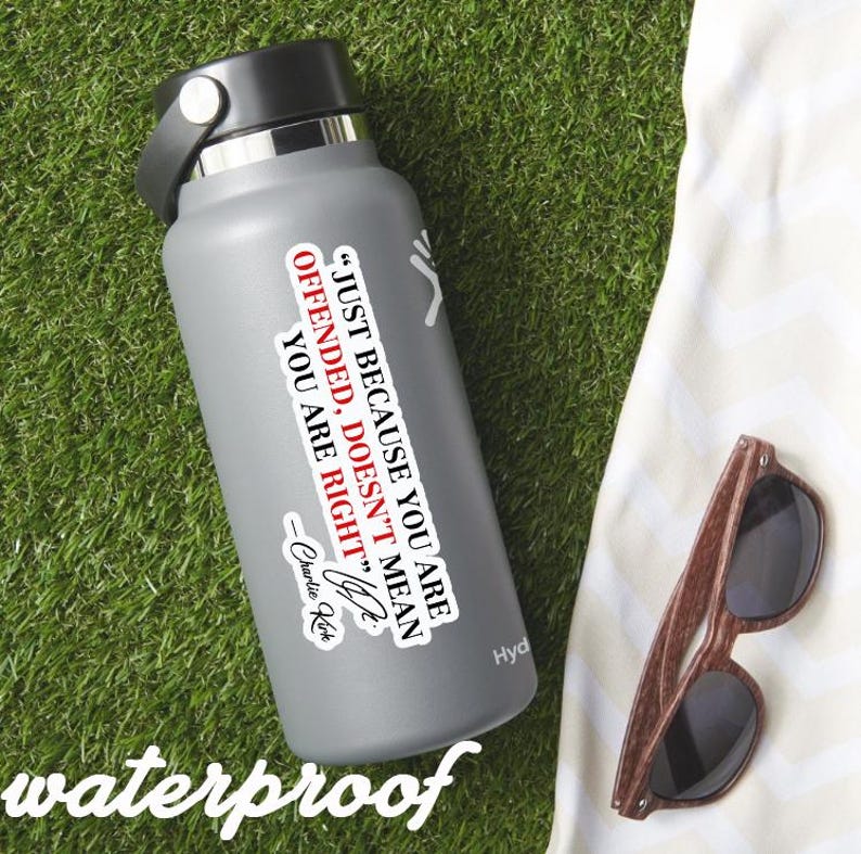 May include: A gray water bottle with a black lid and a white sticker that reads "JUST BECAUSE YOU ARE OFFENDED, DOESN'T MEAN YOU ARE RIGHT" by Charlie Kirk. The word "waterproof" is at the bottom. Brown sunglasses are next to the bottle.